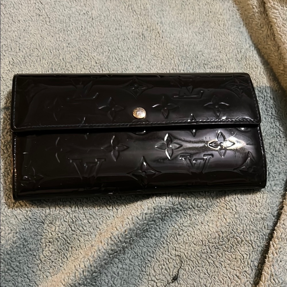 Louis Vuitton Black Wallet with Embossed Design and Flap Closure